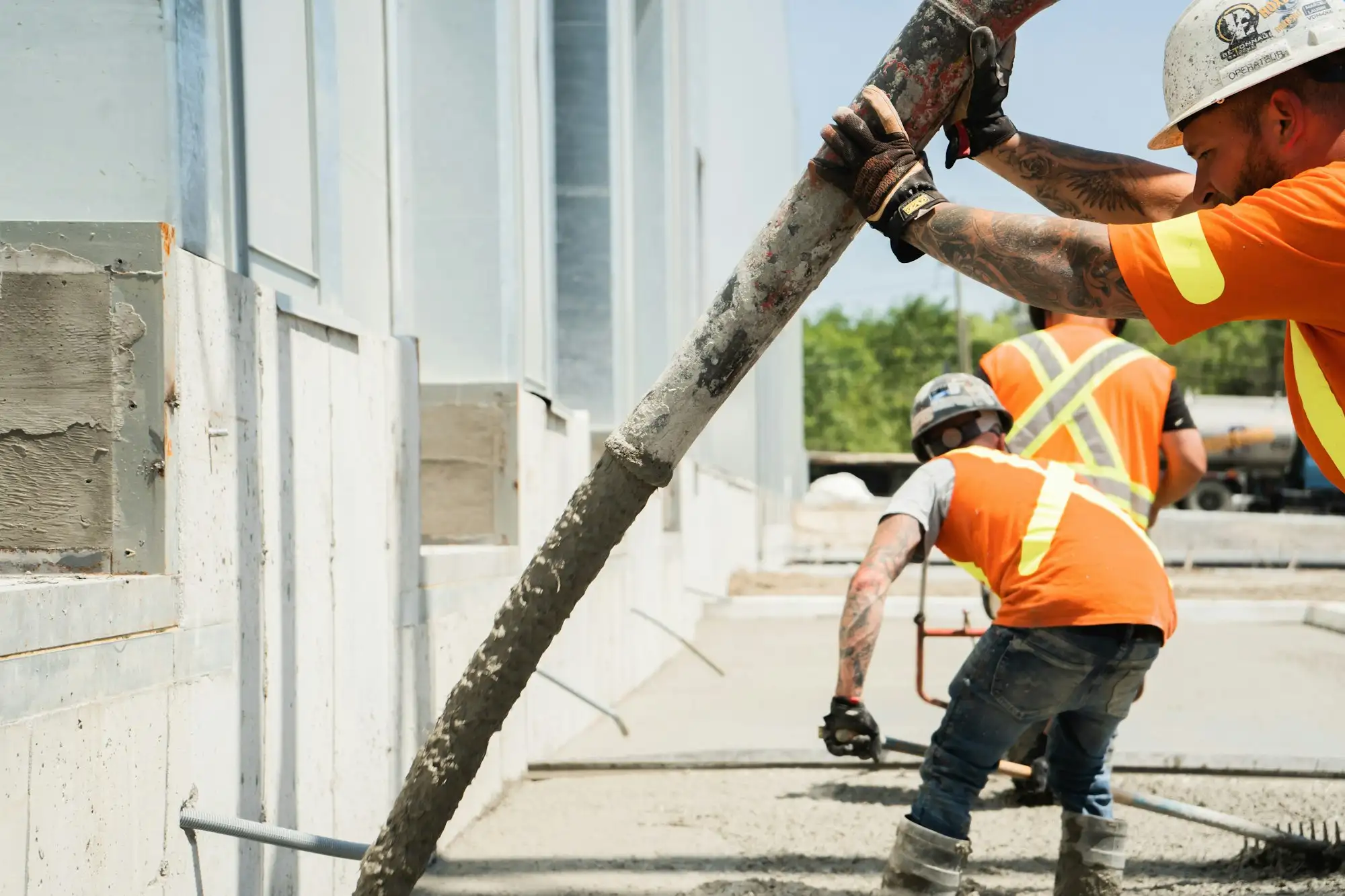 Concreters spreading a fresh concrete pour on an Australian house slab