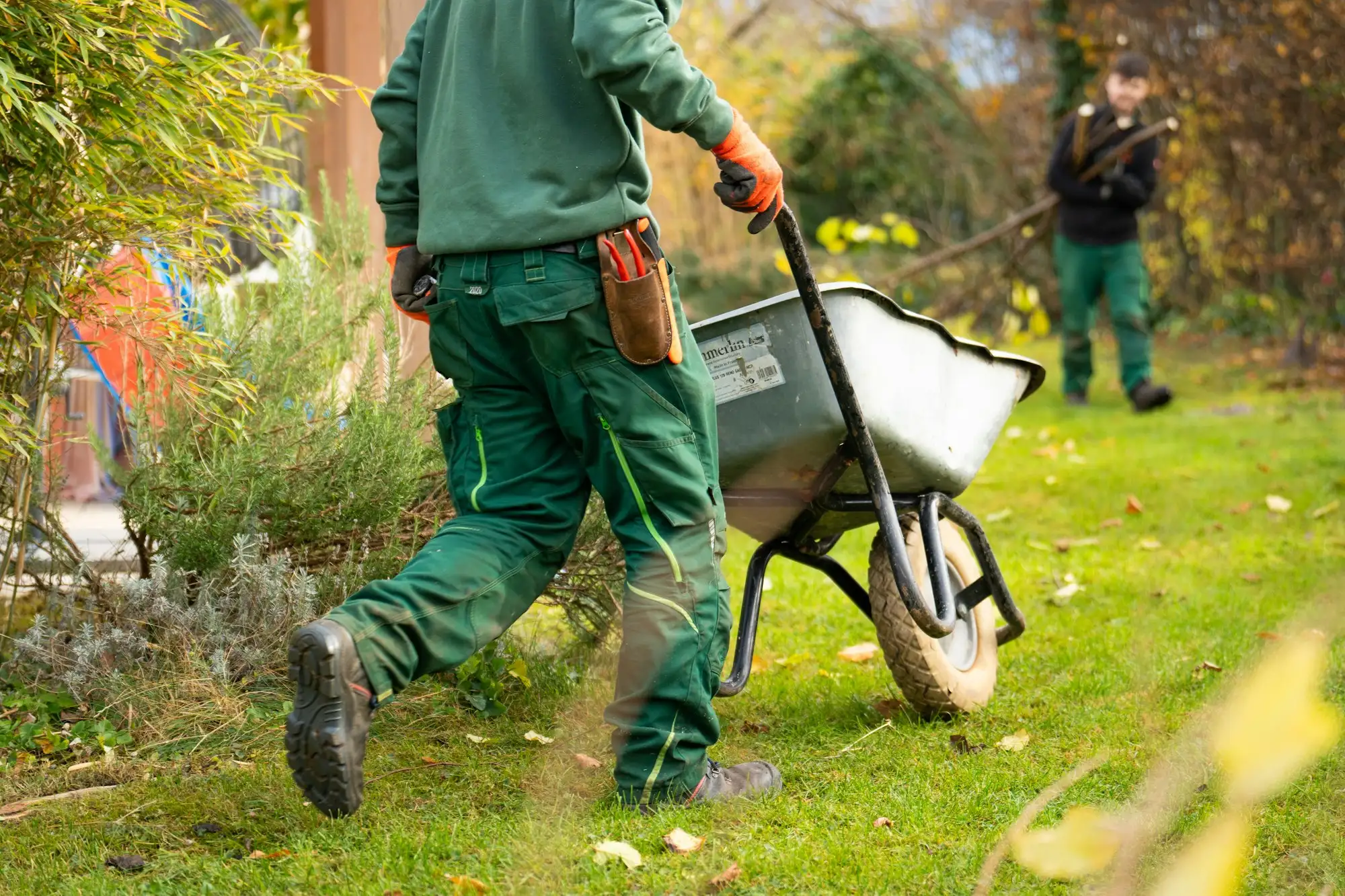 Landscaper pushing a wheelbarrow of soil on a residential landscaping job